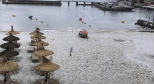 Majorca's beaches are turned white with ICE as freak storm hits