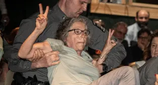 Republican's town hall descends into chaos as woman is carried out