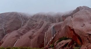 Stunning photos capture the rare moment water cascades down Uluru