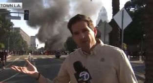 Reporter denies there are riots in LA while chaos unfolds behind him