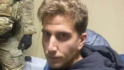 Bryan Kohberger's stone-faced glare at officer at his parents home