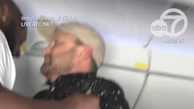 Moment passenger is picked up like a TODDLER during mid-air meltdown